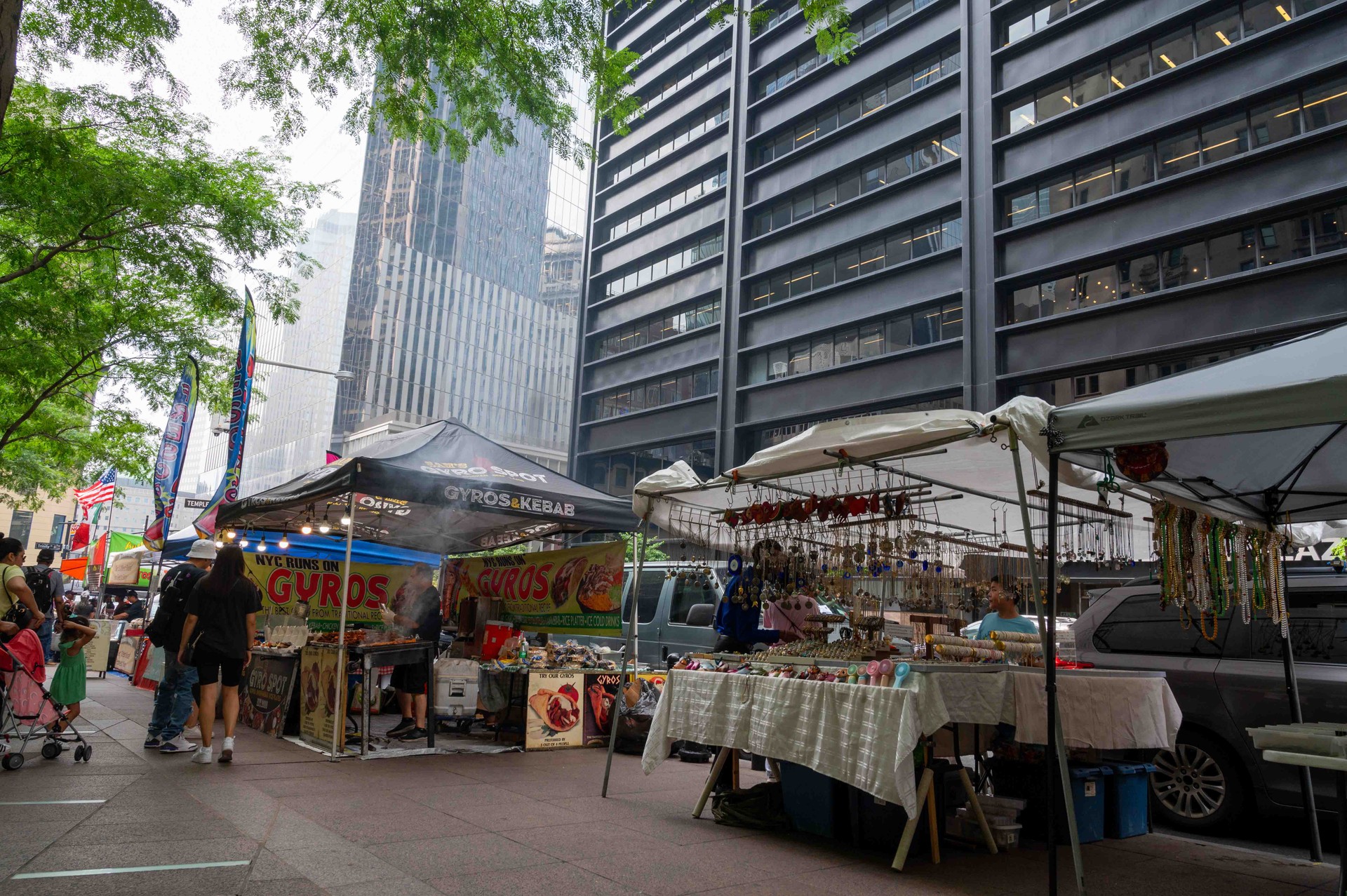 Customers at food and arts and crafts market stalls at street fair Zuccotti Park NYC